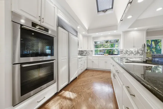 a kitchen with stainless steel appliances kitchen island granite countertop a stove a microwave and a sink