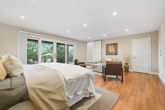 a spacious bedroom with a bed and wooden floor