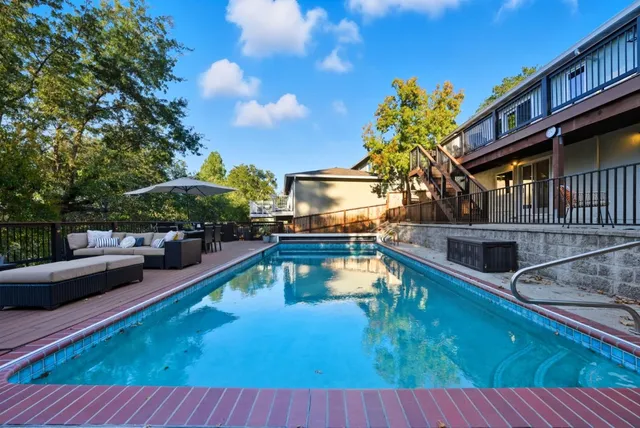 a swimming pool view with a seating space