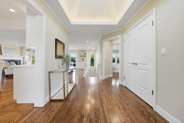 a view of a hallway with wooden floor and a kitchen