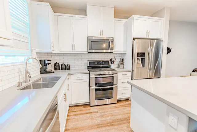 a kitchen with stainless steel appliances a refrigerator stove and sink