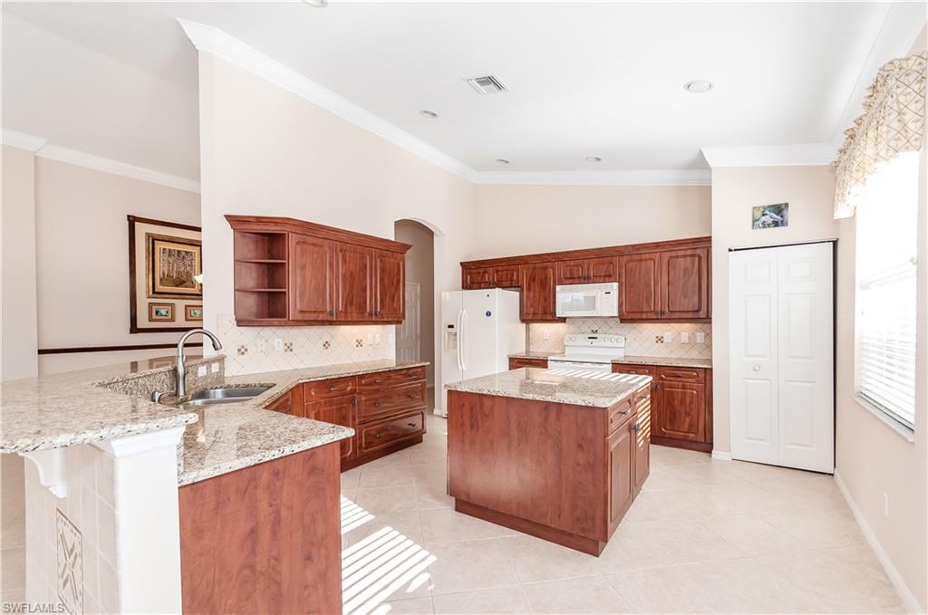 9381 Springview Loop Estero, FL 33928 - Photo 5 of 35 a kitchen with a sink stove and refrigerator