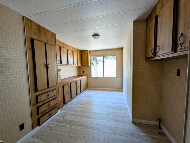 a view of kitchen with wooden floor and electronic appliances