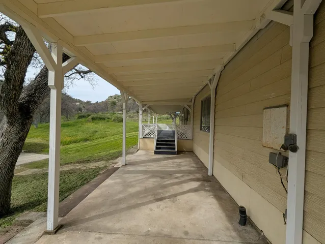 a view of a couches in the patio with a yard