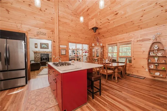 a kitchen that has a table chairs stainless steel appliances and cabinets