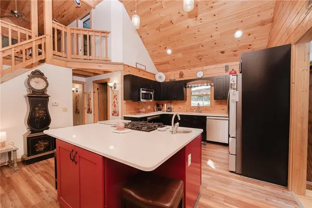 a kitchen with stainless steel appliances granite countertop a sink a stove and a refrigerator