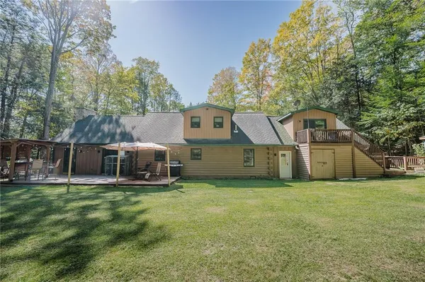a front view of house with yard and trees in the background