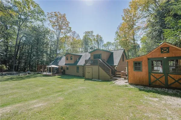 a view of a house with backyard and a tree