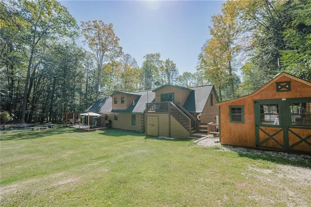 a view of a house with backyard and a tree