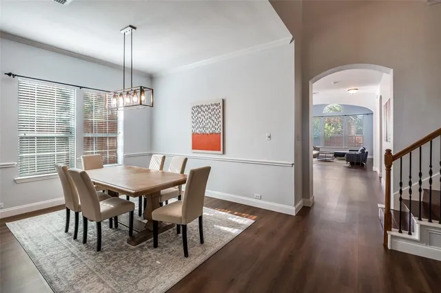 a view of a dining room and livingroom with furniture wooden floor a chandelier