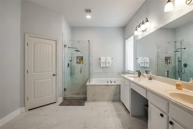 a bathroom with a double vanity sink a large mirror and shower