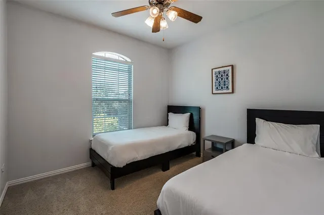 a bedroom with two beds and a chandelier