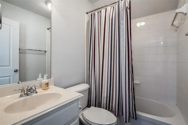 a bathroom with a sink a toilet a mirror and shower