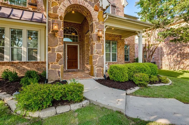 a view of a brick house with a yard and plants