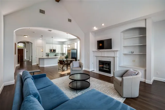 a living room with furniture a fireplace and a flat screen tv