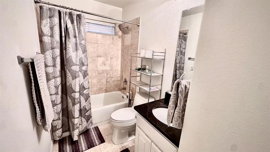 1237 Tioga Drive Irving, TX 75063 - Photo 14 of 15 a bathroom with a toilet a sink and a shower