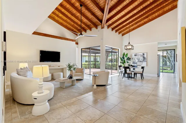 a living room with couches a flat screen tv and kitchen view