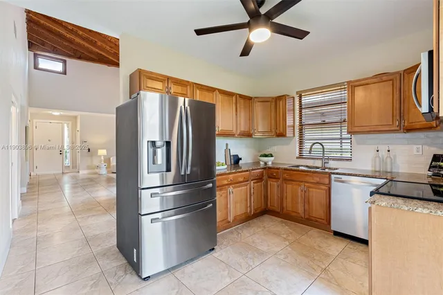 a kitchen with stainless steel appliances granite countertop a refrigerator oven a sink dishwasher and a refrigerator
