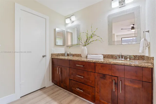 a bathroom with a granite countertop sink and a mirror