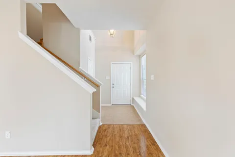 a view of a hallway with wooden floor and staircase
