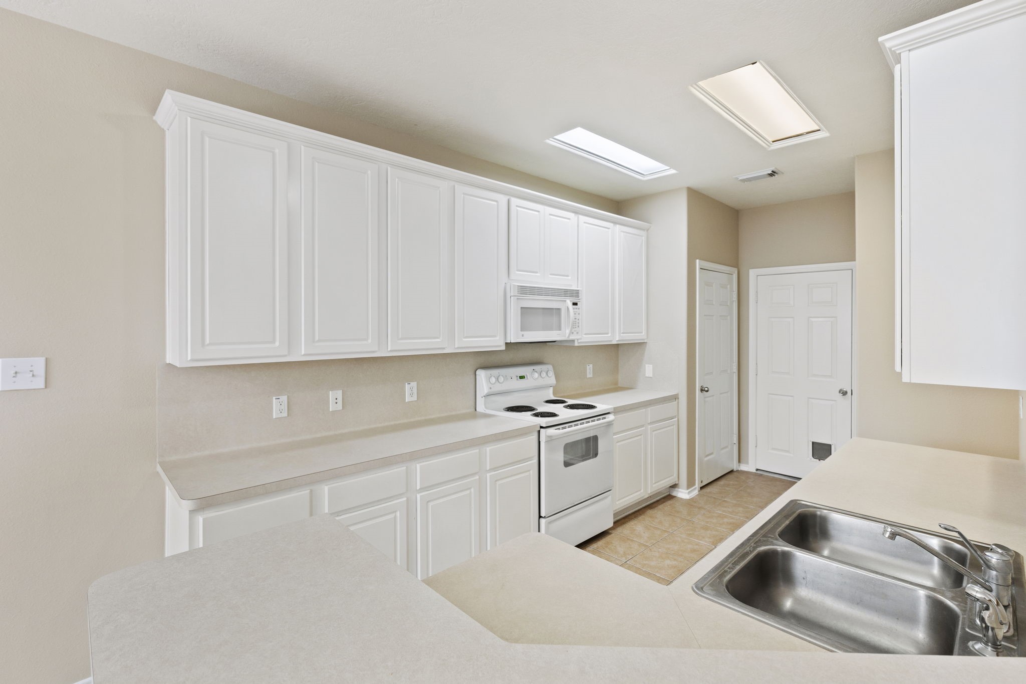 106 East Stedhill Loop Conroe, TX 77384 - Photo 9 of 29 looking over the bartop at the white on white kitchen........