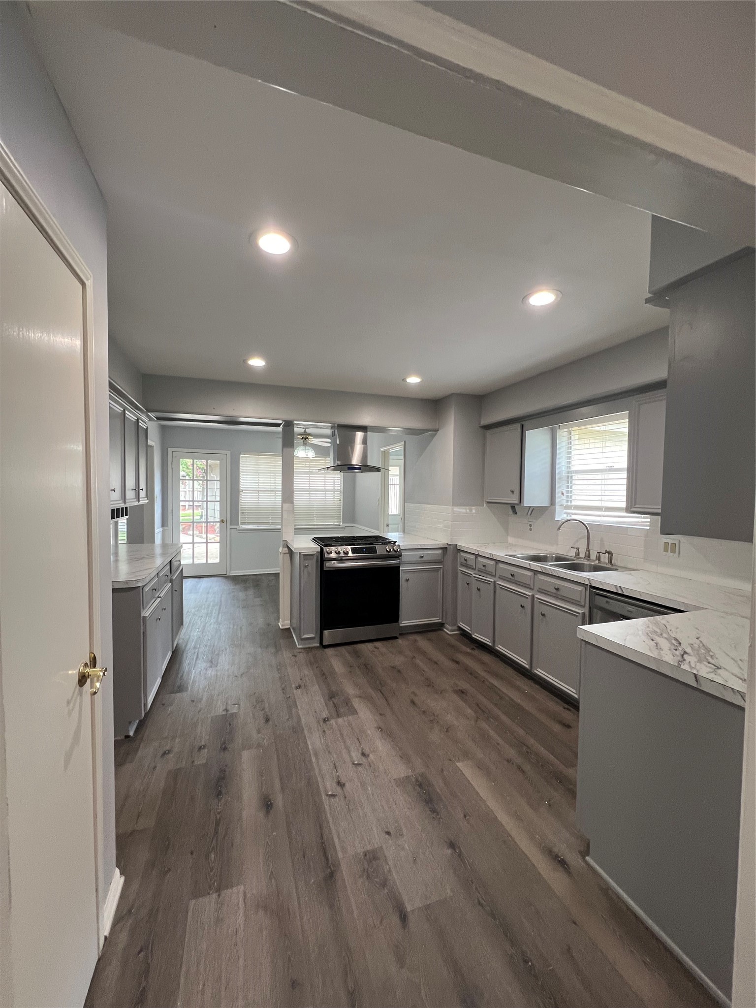 2015 Hamlin Valley Drive Houston, TX 77090 - Photo 11 of 31 a large white kitchen with a stove a sink dishwasher and a refrigerator with wooden floor