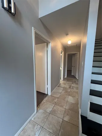 a view of a hallway with wooden cabinets