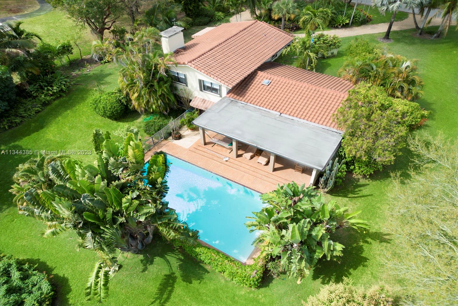 12555 Moss Ranch Road Pinecrest, FL 33156 - Photo 1 of 26 an aerial view of a house with garden space sitting space and garden