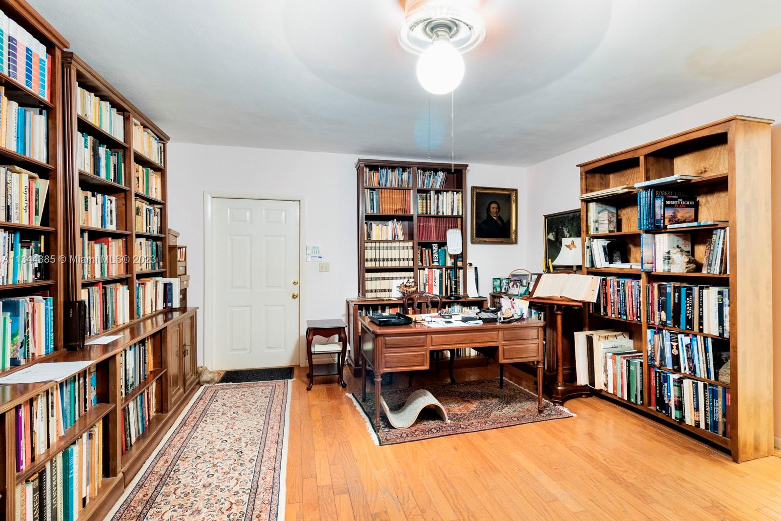 12555 Moss Ranch Road Pinecrest, FL 33156 - Photo 13 of 26 a view of a workspace with bookshelf