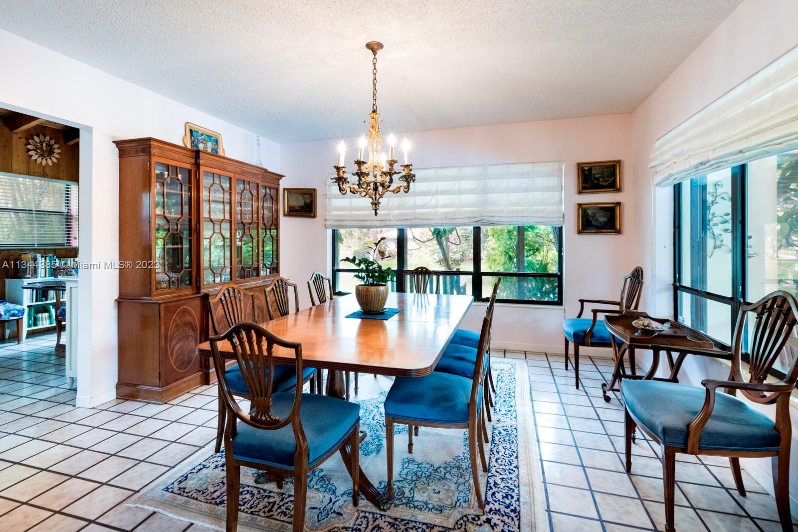12555 Moss Ranch Road Pinecrest, FL 33156 - Photo 16 of 26 a view of a dining room with furniture wooden floor and chandelier