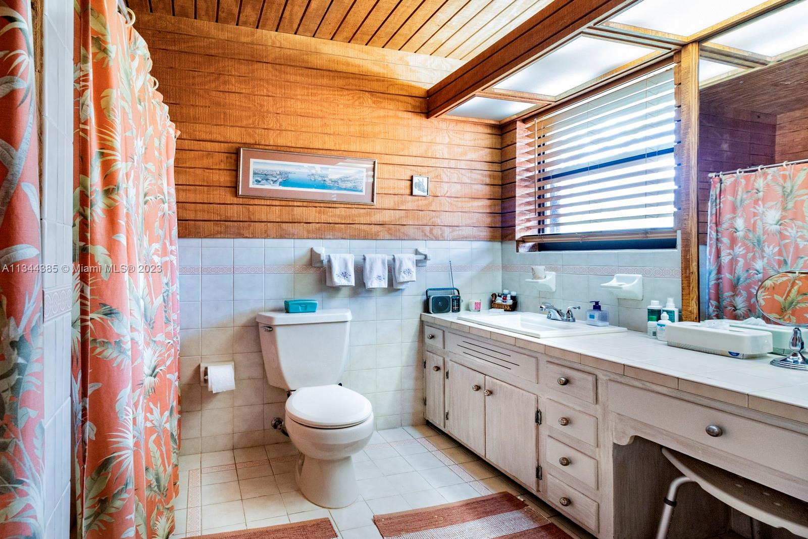 12555 Moss Ranch Road Pinecrest, FL 33156 - Photo 18 of 26 a bathroom with a sink a toilet and a window