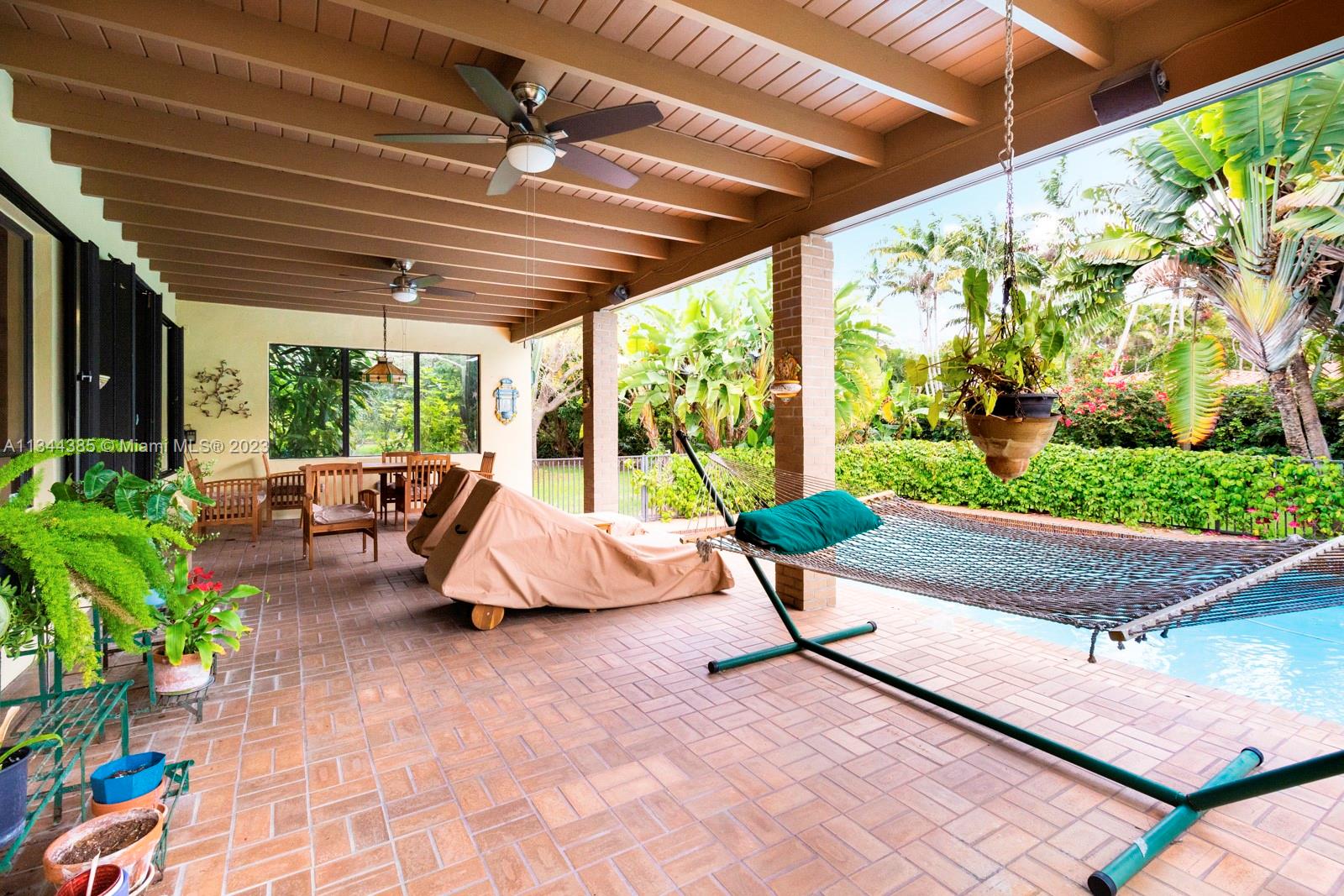 12555 Moss Ranch Road Pinecrest, FL 33156 - Photo 20 of 26 a living room with patio furniture and a potted plants