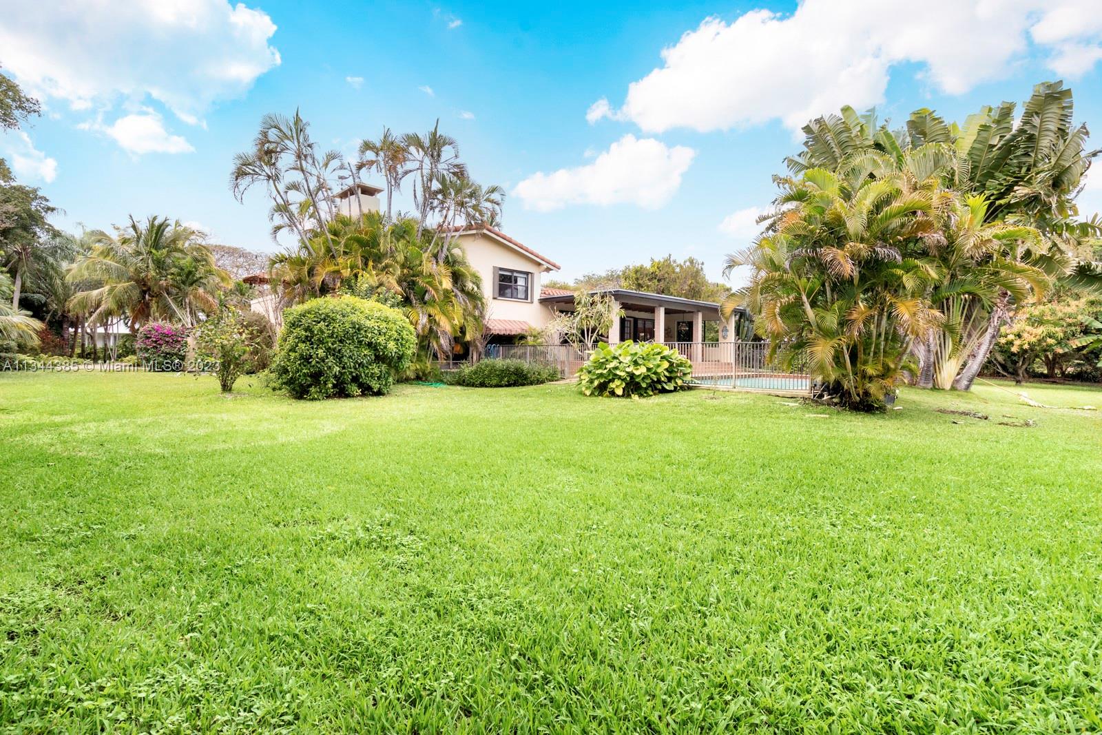 12555 Moss Ranch Road Pinecrest, FL 33156 - Photo 22 of 26 a front view of a house with a garden