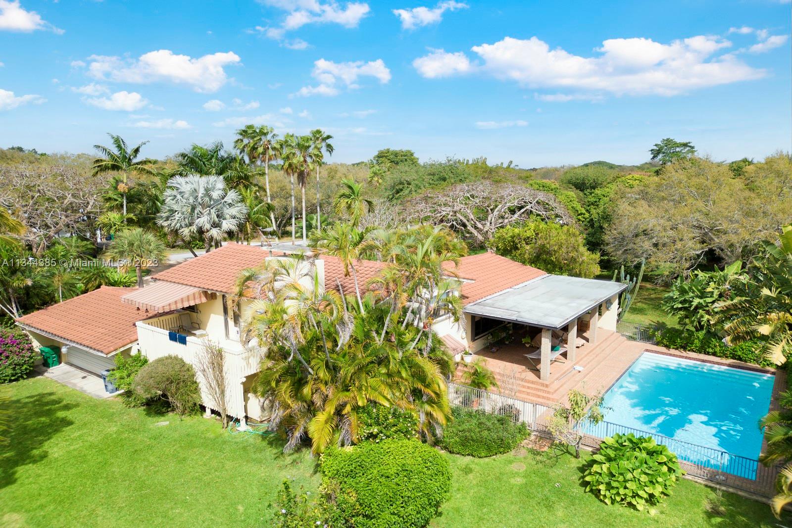 12555 Moss Ranch Road Pinecrest, FL 33156 - Photo 3 of 26 an aerial view of a house with yard and outdoor seating