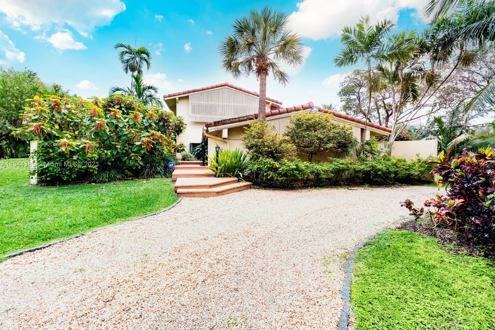 12555 Moss Ranch Road Pinecrest, FL 33156 - Photo 6 of 26 a front view of a house with a yard and fountain
