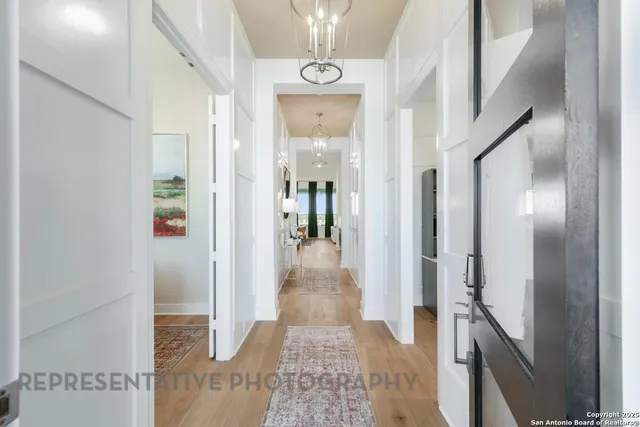 a view of a hallway with wooden floor and staircase