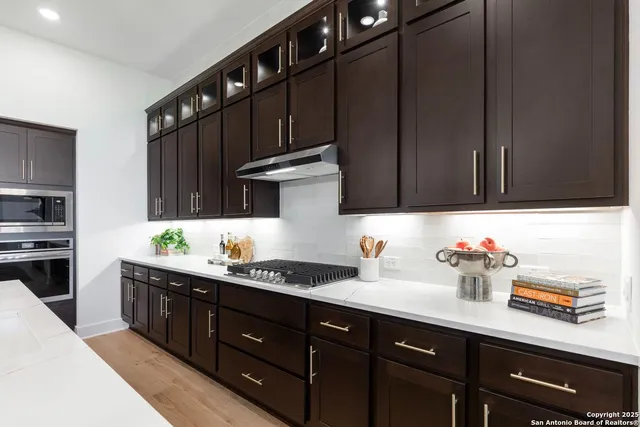 a bathroom with a sink a potted plant and windows