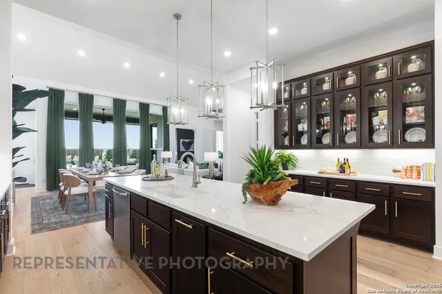 a kitchen with a sink a counter top space and living room view