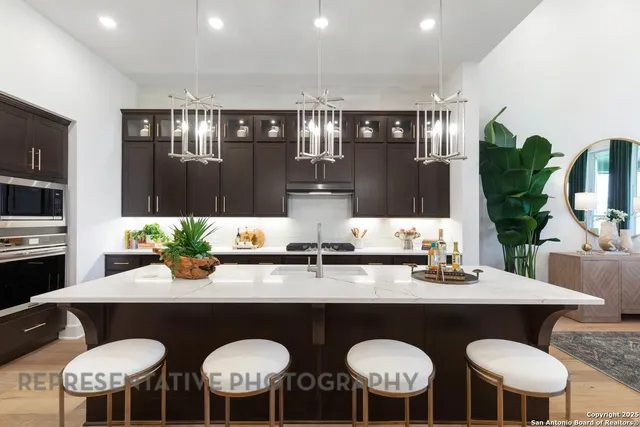 a kitchen with stainless steel appliances granite countertop a sink and chairs