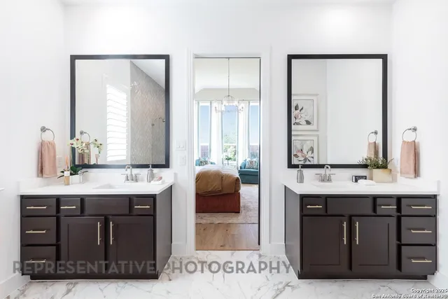 a en suite bathroom with a double vanity sink a mirror and a bathtub