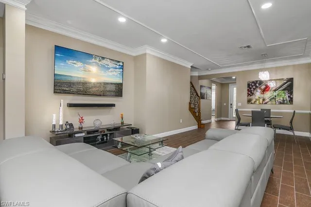 a living room with furniture a flat screen tv and kitchen view