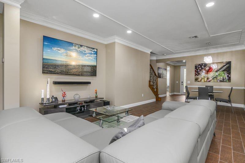 16309 Winfield Lane Naples, FL 34110 - Photo 11 of 36 a living room with furniture a flat screen tv and kitchen view