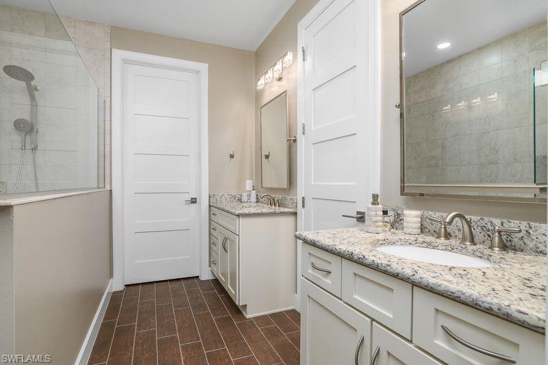 16309 Winfield Lane Naples, FL 34110 - Photo 17 of 36 a bathroom with a granite countertop sink a mirror and a shower