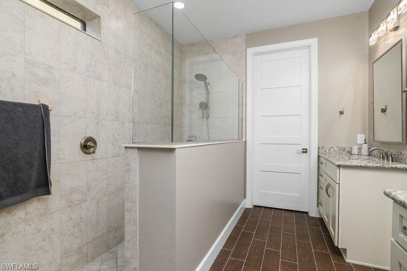 16309 Winfield Lane Naples, FL 34110 - Photo 19 of 36 a bathroom with a granite countertop shower a sink and a mirror