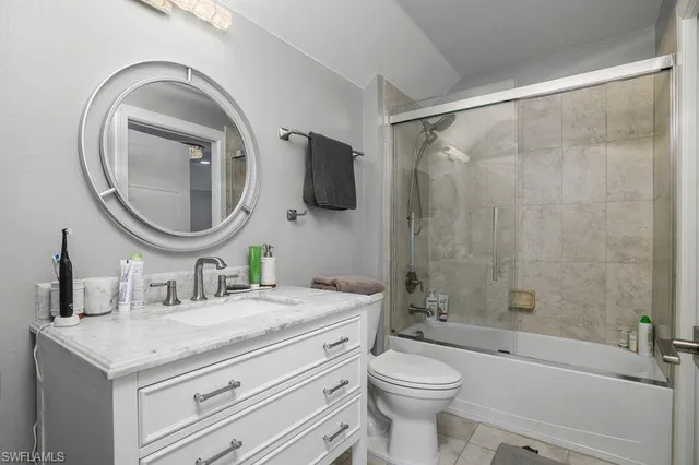 a bathroom with a granite countertop sink a toilet and a mirror