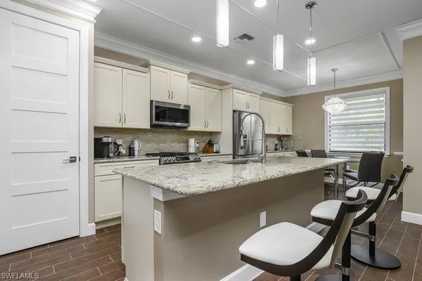 a kitchen with a table chairs sink and cabinets