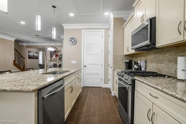 a kitchen with stainless steel appliances granite countertop a stove a sink and a microwave