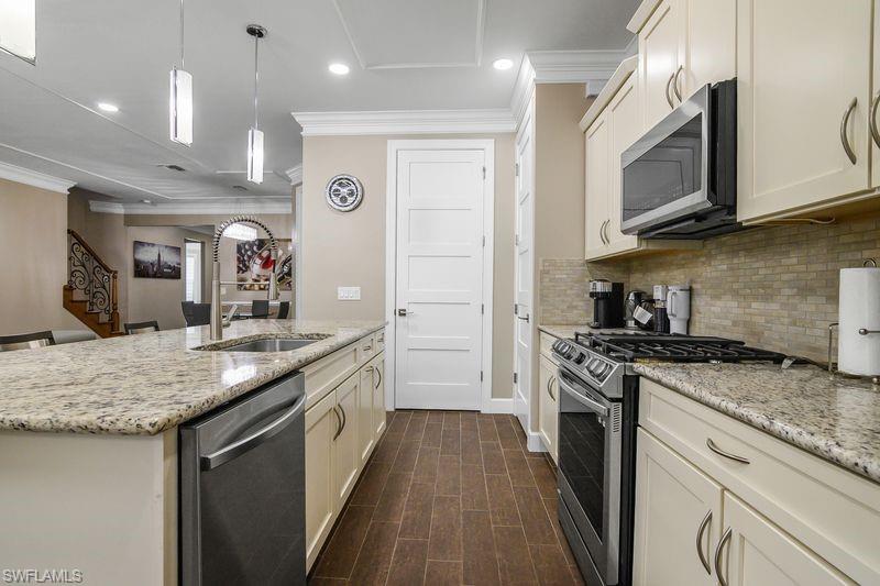 16309 Winfield Lane Naples, FL 34110 - Photo 7 of 36 a kitchen with stainless steel appliances granite countertop a stove a sink and a microwave
