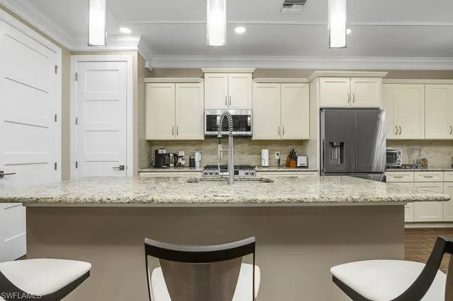 a kitchen with stainless steel appliances granite countertop a sink refrigerator and cabinets