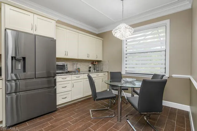 a kitchen with a refrigerator a table and chairs in it